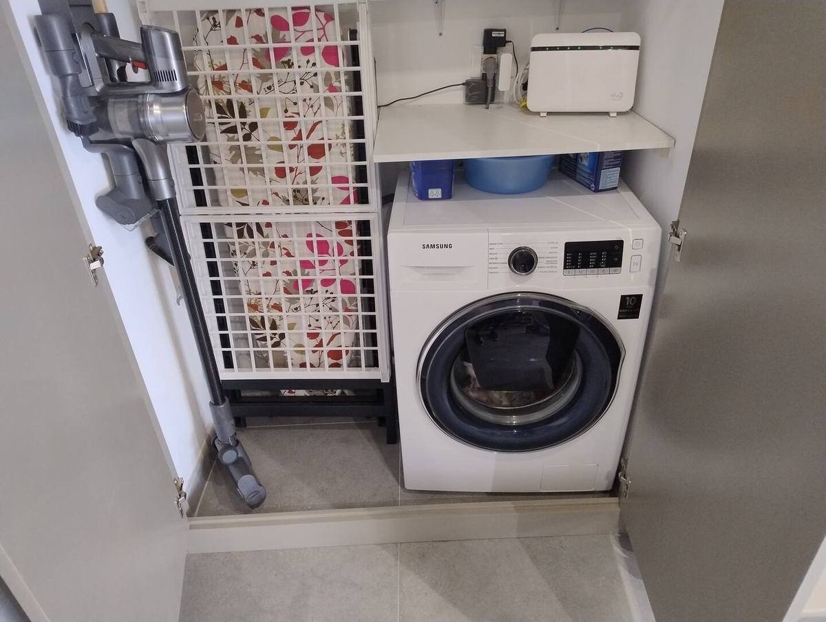 Washing machine, ironing board and vacuum cleaner in a closet